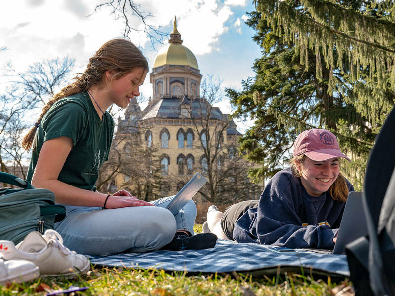 Students working on blanket during a spring day on campus